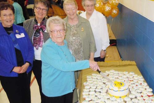 former long time school care taker Bernice Gunsinger of Plevna cut the anniversary cake at CCPS's 50th Anniversary celebrations on April 12